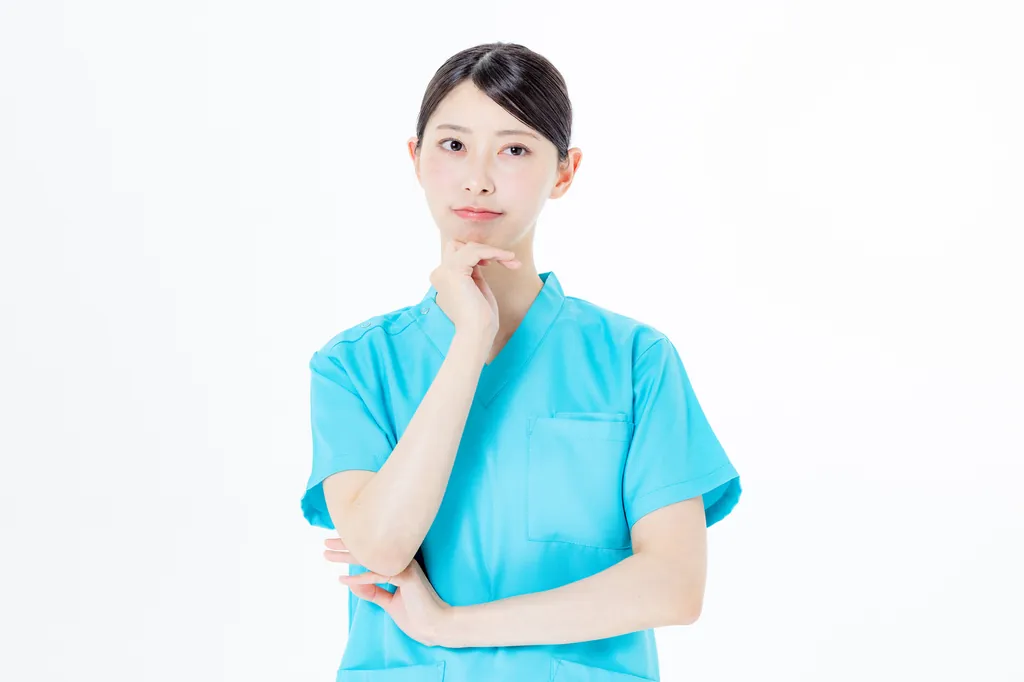 腕を組んで考えごとをしている看護師