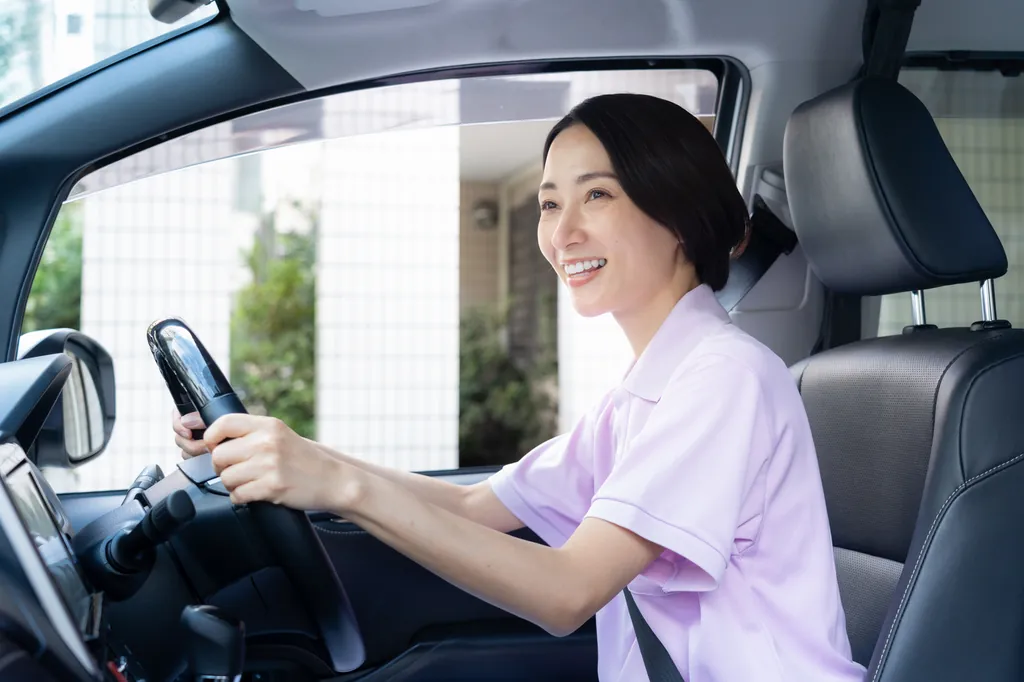 訪問先へ向かうため車を運転する看護師
